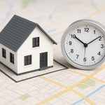 A model house next to a clock on a map backdrop, symbolizing real estate deadlines.